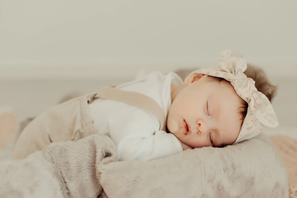 Beba u prelepom bez komletu spava na udobnom cebetu.
